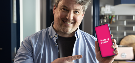 Man smiling pointing at PrepayPower app on his phone